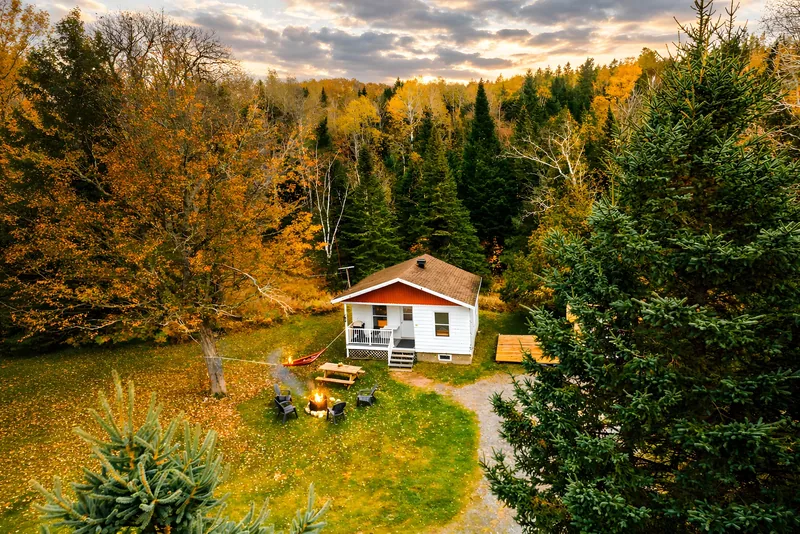 Le Sorbier — Vue aérienne du chalet et de la pelouse entourés d’arbres